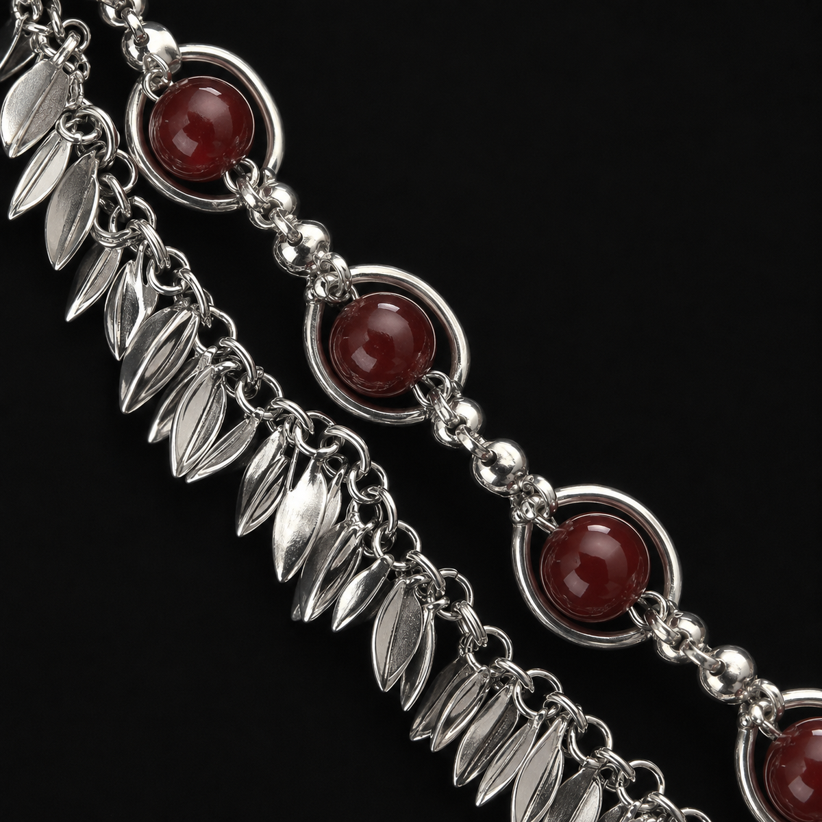 Close-up of deep red beads and silver-tone leaf fringe on the gothic necklace