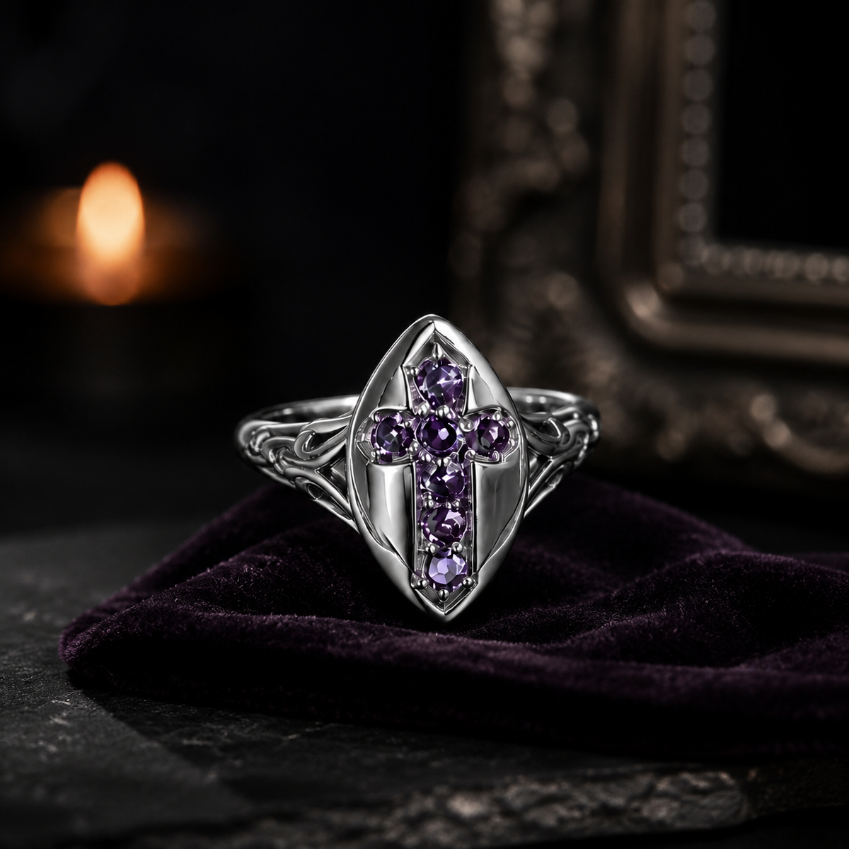 Purple cross shield ring displayed on deep plum velvet in a gothic candlelit setting