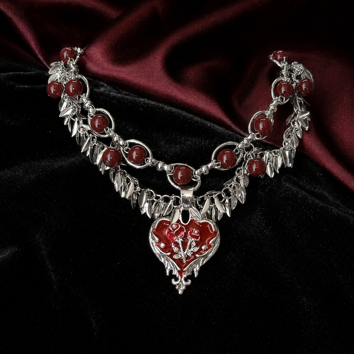 Gothic red heart rose necklace styled on black velvet and burgundy satin