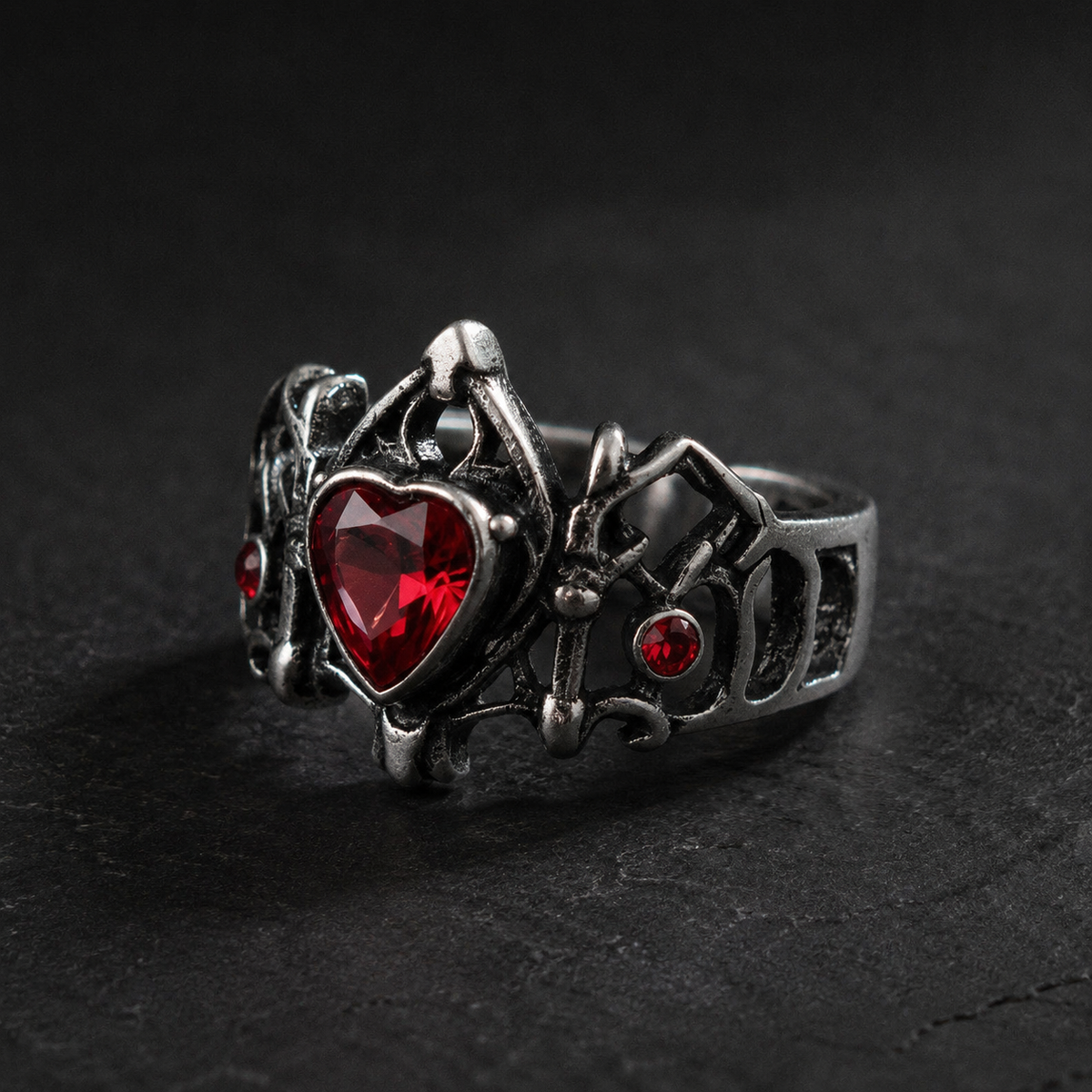 Side view showing the openwork band and red stones of the gothic heart ring