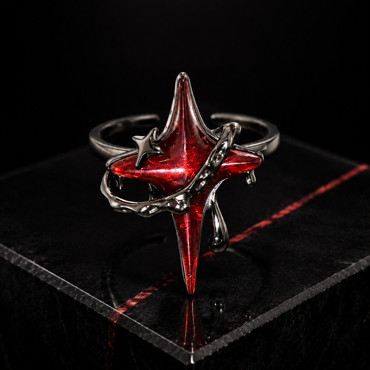 Adjustable red star open ring displayed on a polished black stone plinth